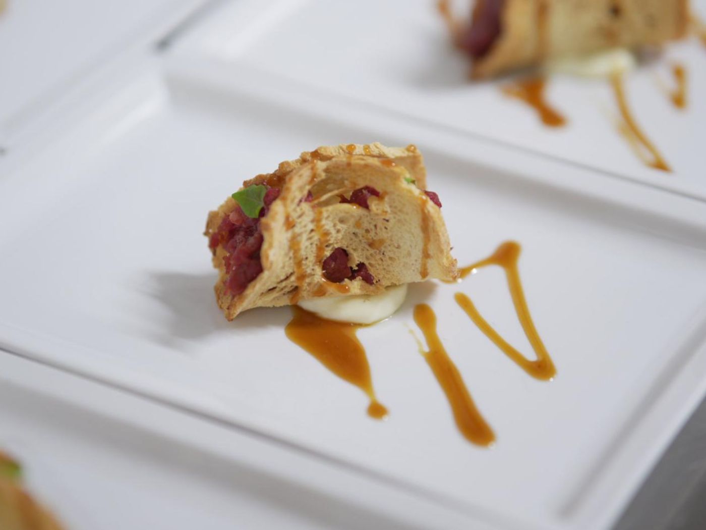 Impiattamento fine dining su piatto bianco