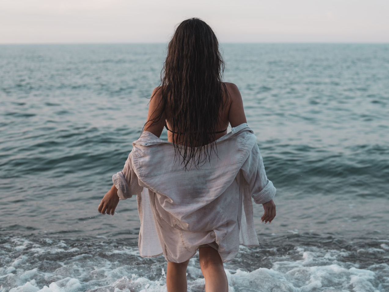 Ragazza di spalle davanti al mare