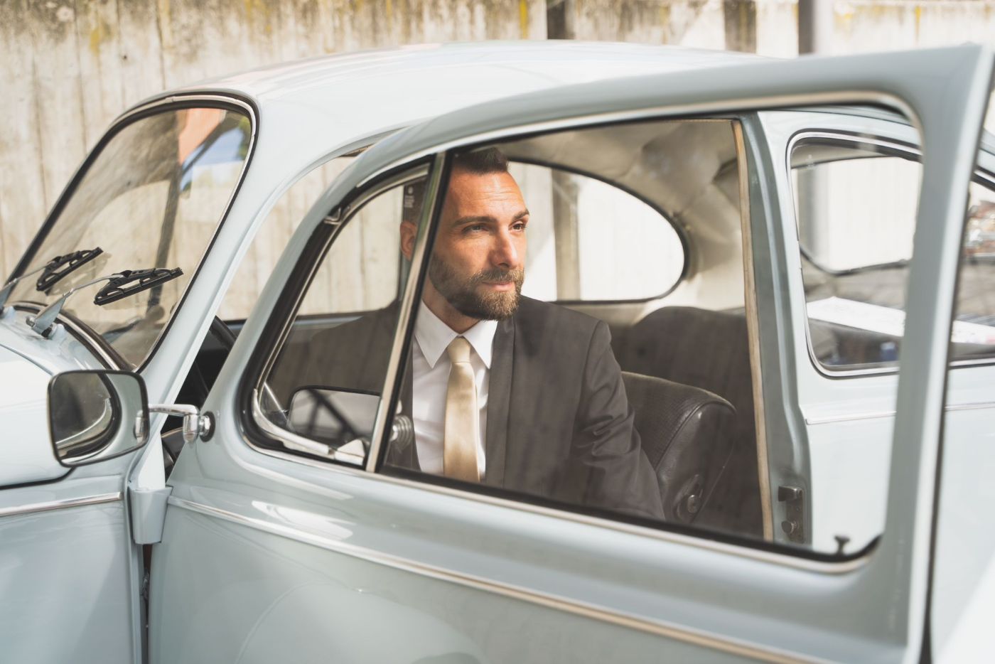 Lo sposo seduto in un'auto d'epoca